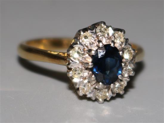 An 18ct gold sapphire and diamond oval cluster ring, size O.
